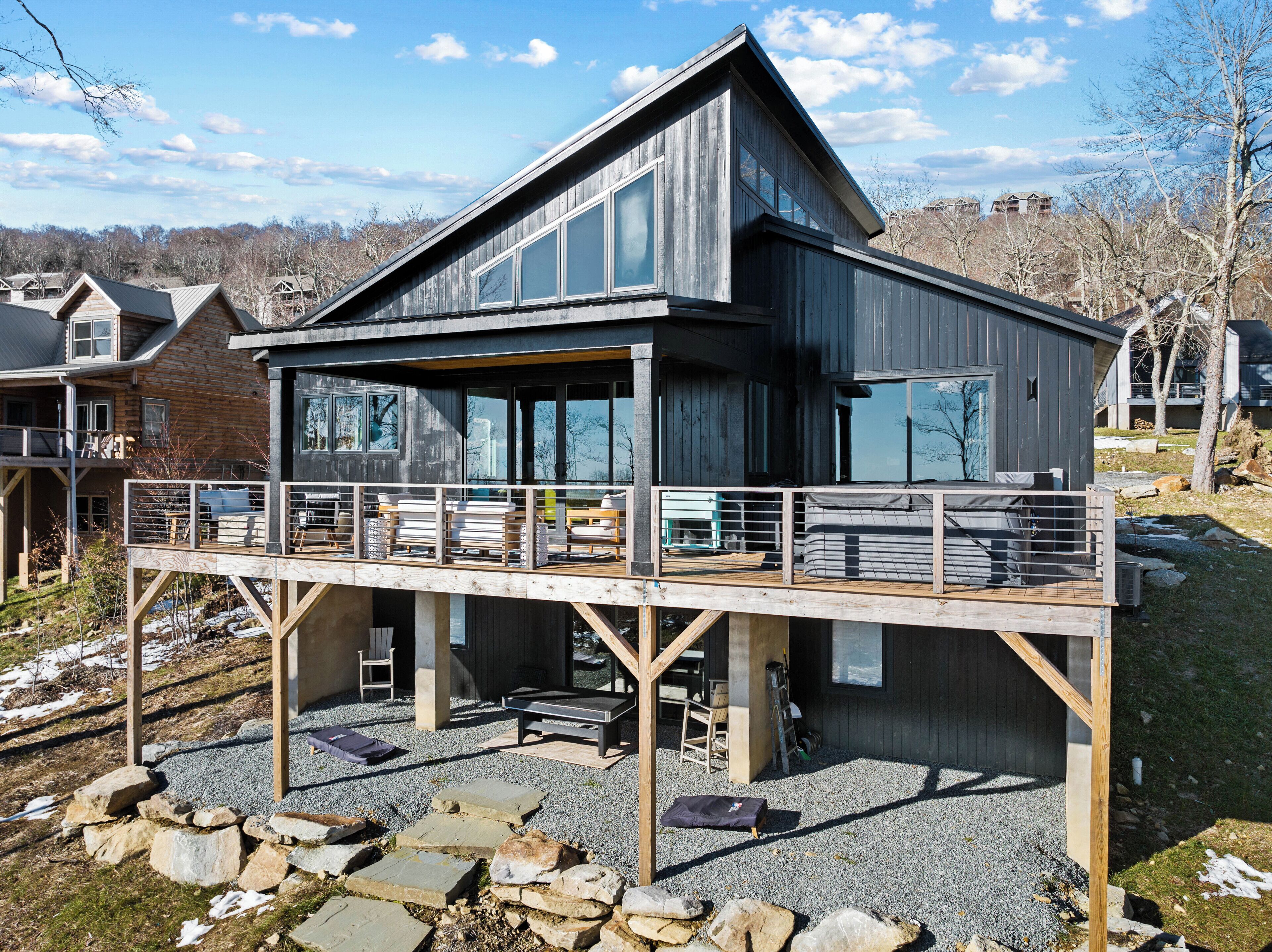 Una casa moderna de madera con terraza, ventanas amplias y cimientos de piedra.