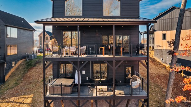 Une maison à deux étages avec un balcon, de grandes fenêtres et un garage.