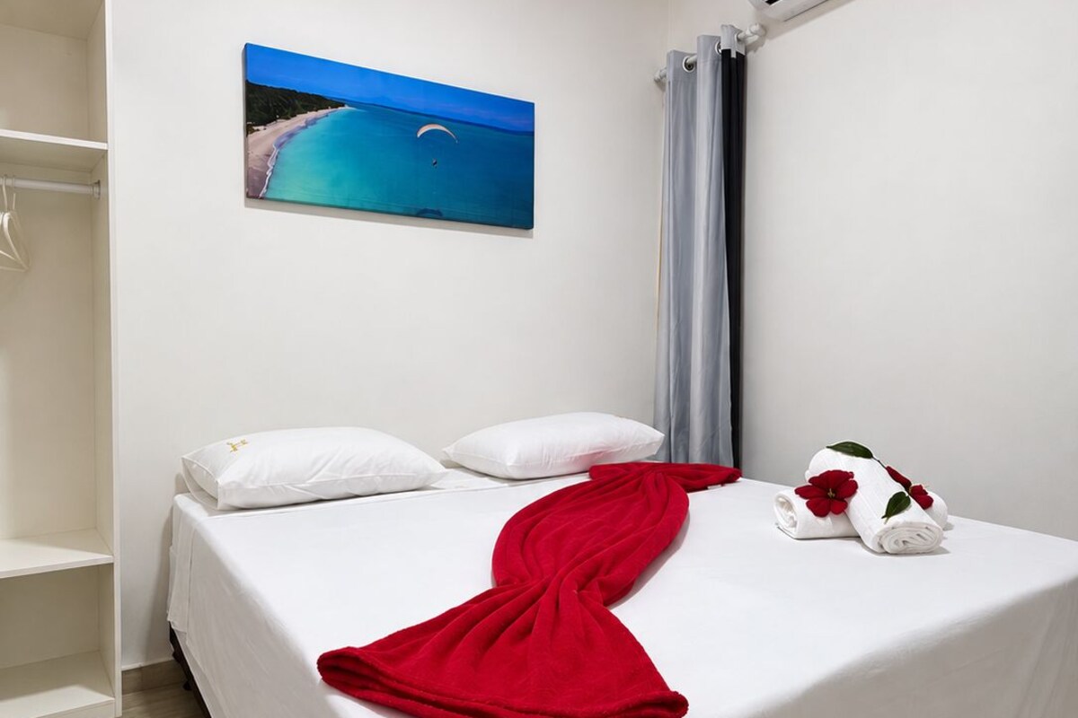 Habitación de hotel con cama, un cuadro, equipo de aire acondicionado y un armario.