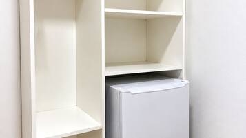 A white wardrobe with open doors, revealing shelves and hanging space.