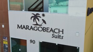 Un edificio con un cartel que dice 'MARAGOBEACH Suites' y el número 90.