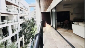 Een modern appartement met balkon, een eethoek en uitzicht op omliggende gebouwen.