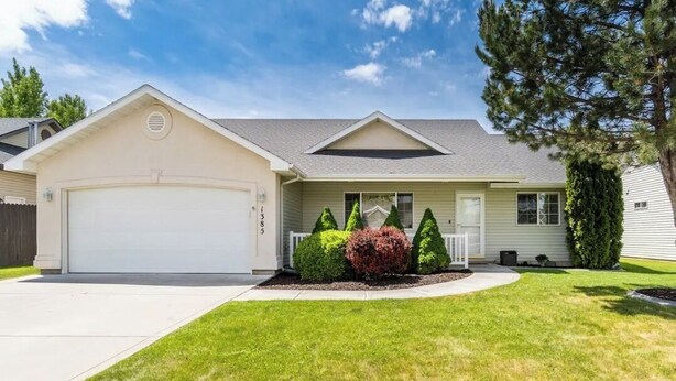 A single-story house with a garage, a front porch, and a well-maintained lawn.