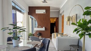 Una sala de estar moderna con un sofá, sillas, una mesita de centro y plantas en macetas.