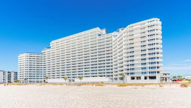 Een hotel met meerdere verdiepingen, modern vormgegeven, met balkons en grote ramen.
