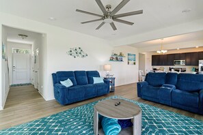A living room with two sofas, a coffee table, and a ceiling fan. - Robert's Retreat | 5BR Marsh Views + Decks, Pools, Golf & Captain's Cove Amenities (Greenbackville)