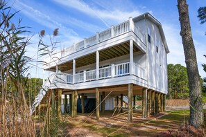Uma casa de dois andares com varanda, deck de madeira e entrada coberta.