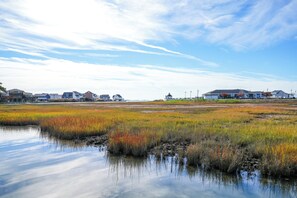 A coastal landscape with houses and a body of water reflecting the sky.