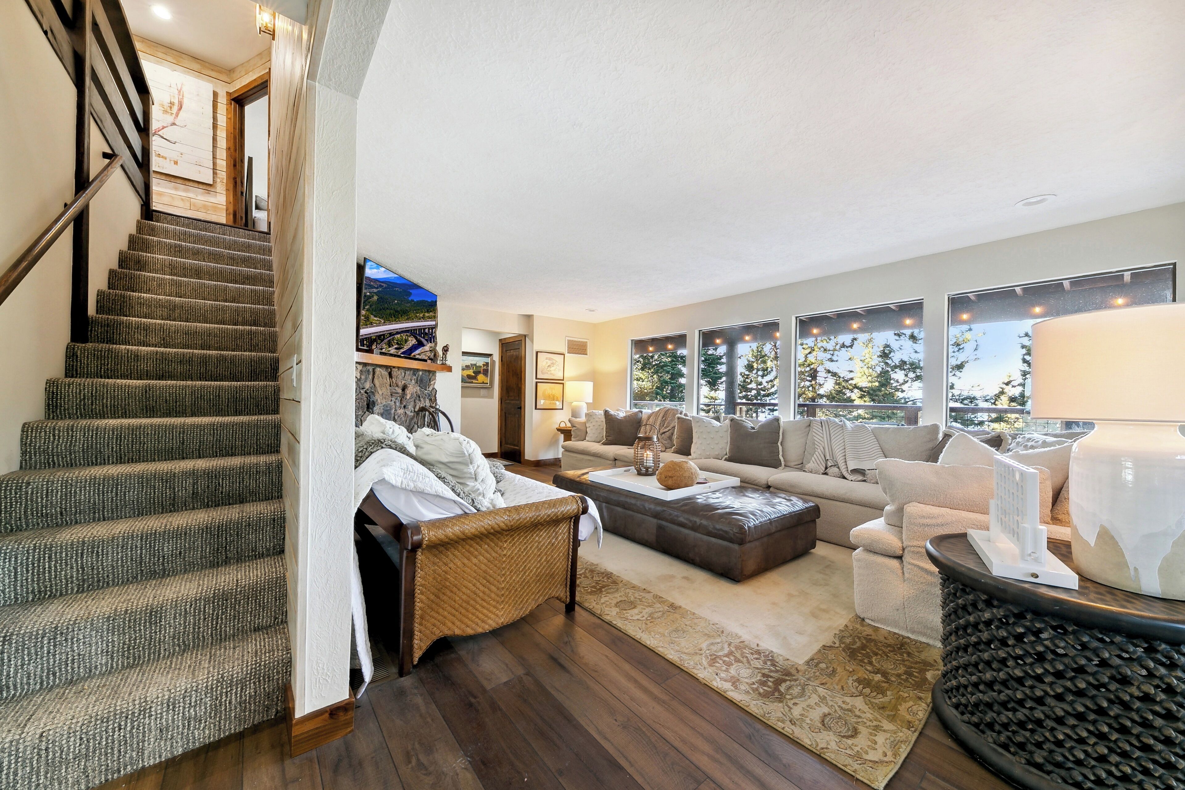 Ein geräumiges Wohnzimmer mit einer großen Couch, einem Couchtisch und einer Treppe zu einer oberen Ebene.
