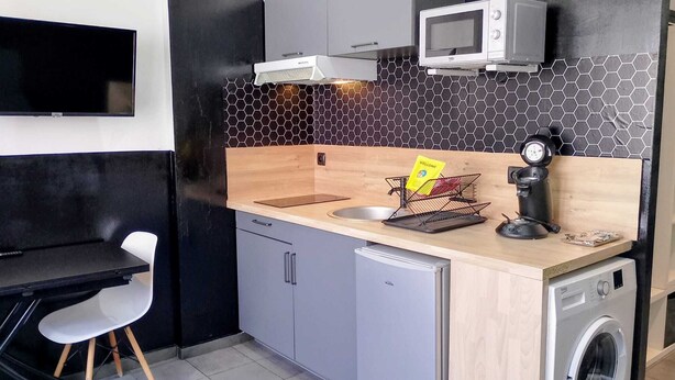 A compact kitchen with a microwave, coffee machine, sink, and a washing machine. - “black studio”, wifi, Bollaert, 3 pers, RDC (Lens)