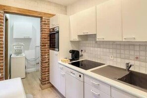 Compact kitchen with oven, microwave, and stainless steel sink, perfect for small-scale cooking needs.