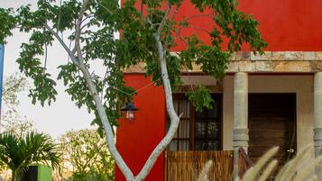 A red building with a white tree in the foreground.