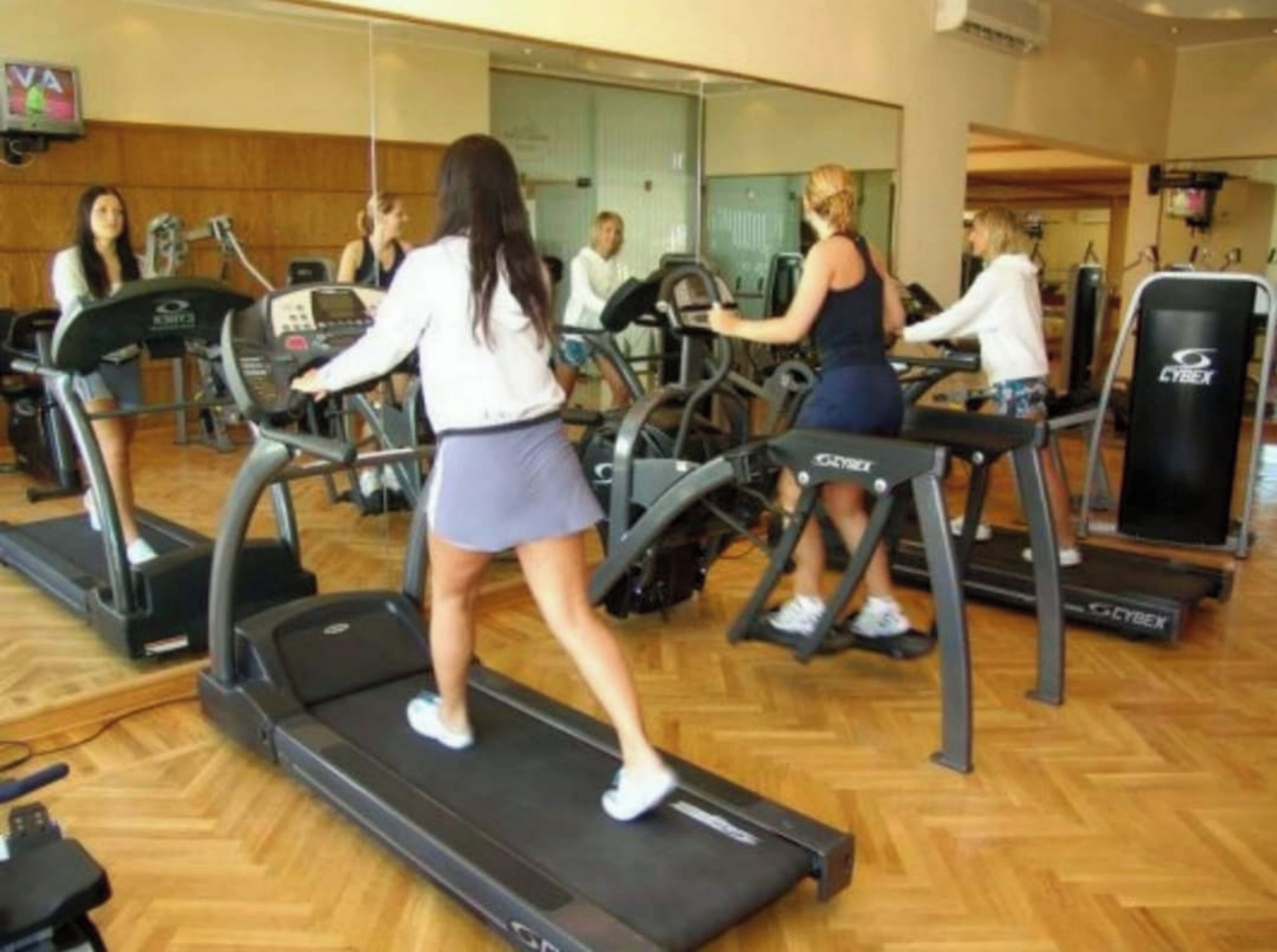 Et fitnesscenter med løbebånd og træningsudstyr.