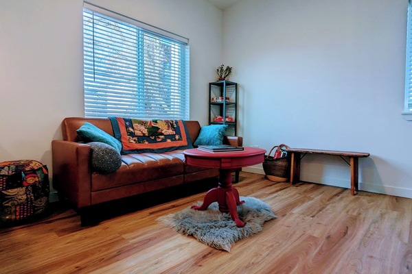 Living room seating area with smart TV. Couch folds out to a double bed.