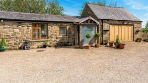 A stone cottage with a gravel driveway, a wooden door, and potted plants. - Meagill Cottage, Sleeps 4 With Hot Tub & Parking (Otley)