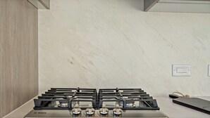 A kitchen with a Bosch gas stove, marble backsplash, and wooden cabinetry.