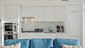 A modern kitchen with white cabinets, a built-in oven, a coffee maker, and a toaster. - Downtown |Views | Luxury | Sunny (Washington)