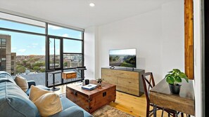 Relax in this stylish living room with a city view, featuring a sofa, coffee table, and flat-screen TV.