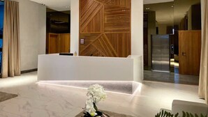 A modern reception area with a wooden panel wall, a reception desk, and a reception counter. - GOISTAY ROMANTICA VISTA A LAS MONTAÑAS (Santo Domingo)