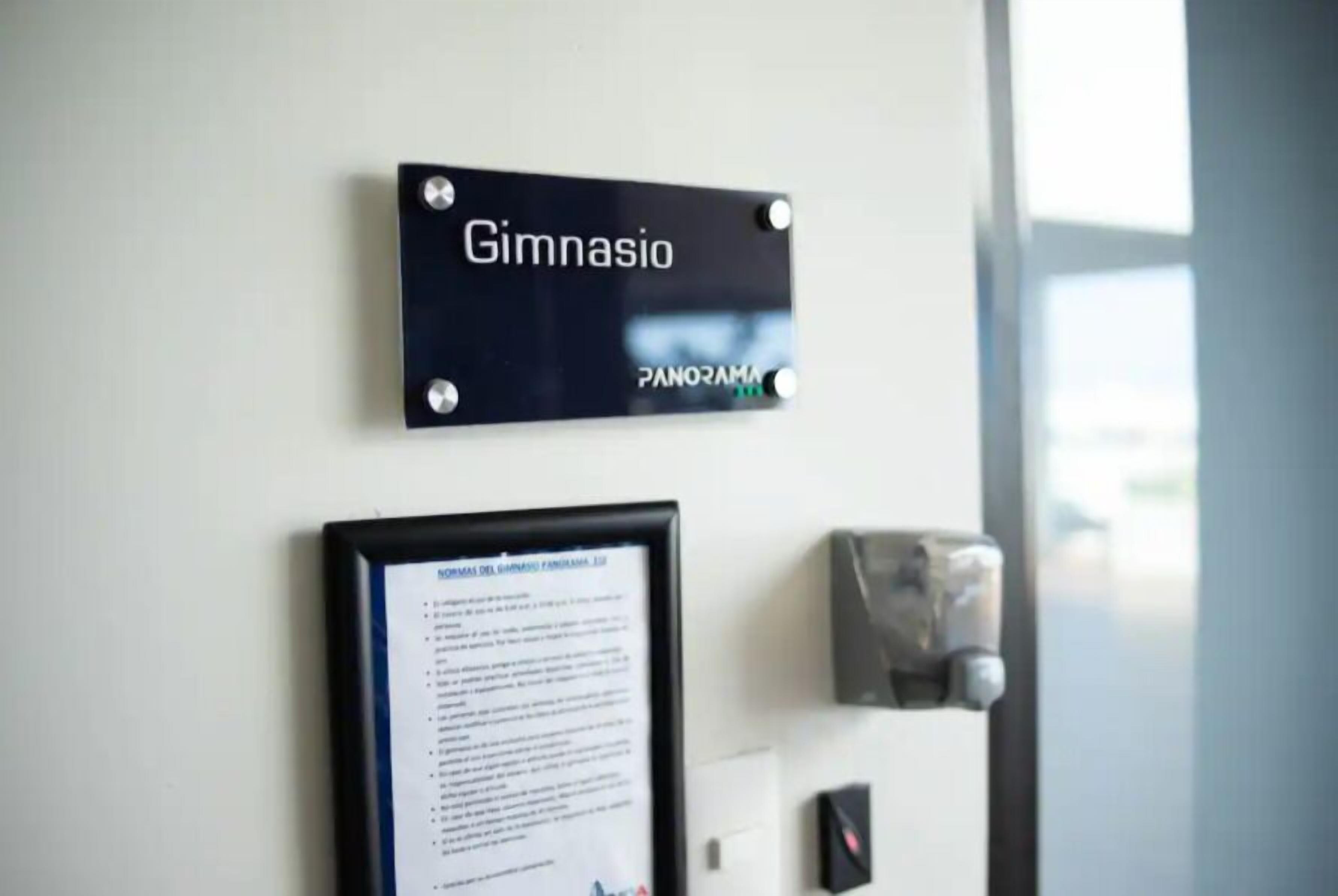 A black sign with the word "Gimnasio" and "PANORAMA" on a wall.