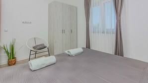 A bedroom with a bed, a chair, a wardrobe, and a potted plant. - Lovely apartment in Vir with WiFi (Vir)