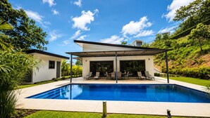 A modern house with a swimming pool, covered patio, and lush greenery. - Large Modern 3-BED house with pool, AC and WiFi in Uvita (Uvita)