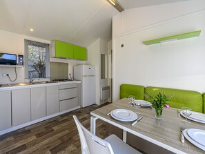 Een koelkast, een microgolfoven, kookgerei, borden en bestek