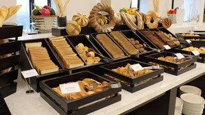A buffet with various food items including bread, pastries, and desserts. - Adamo Hotel Hung Yen (Yen My)