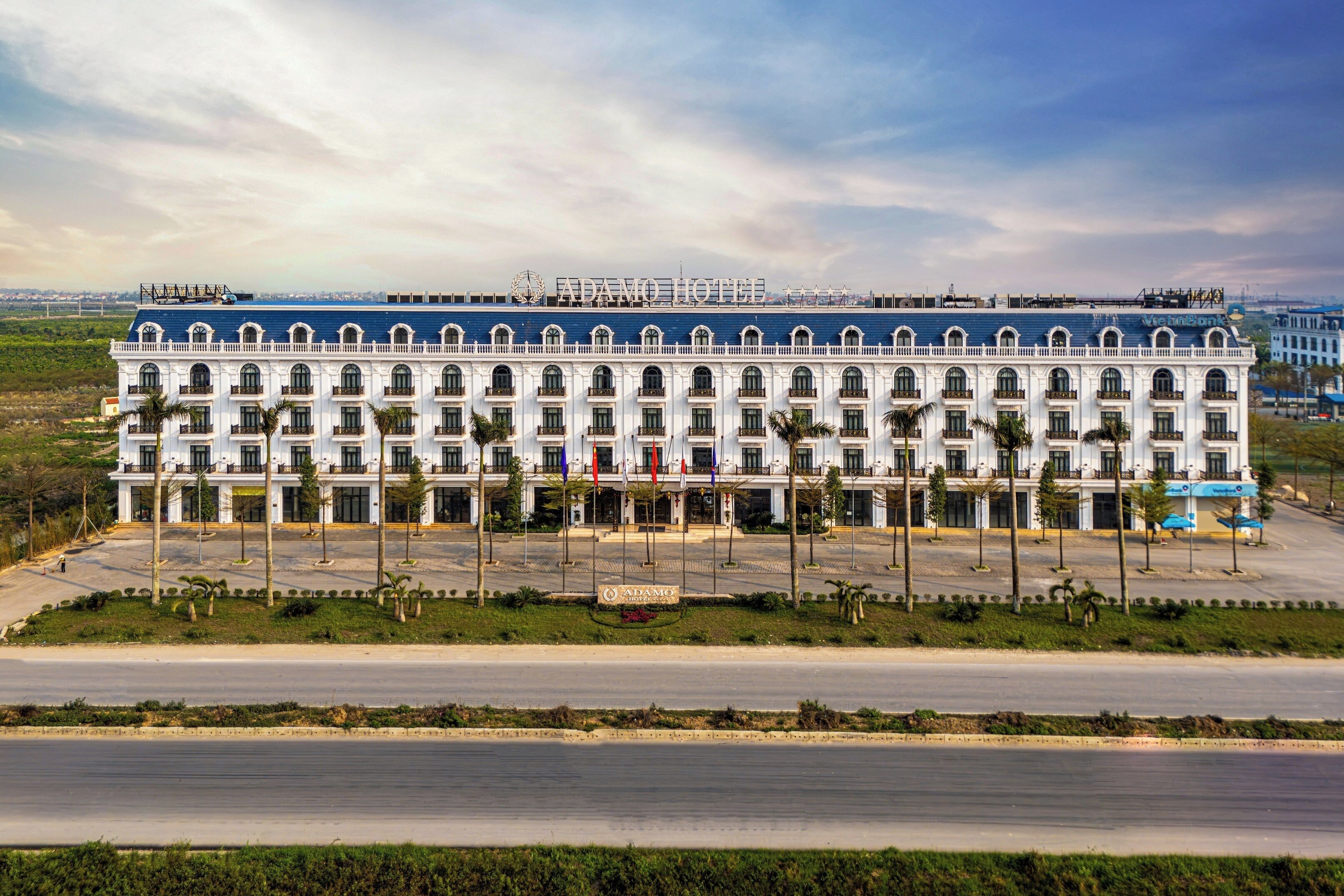 Un grand hôtel à plusieurs étages, doté d’une façade symétrique, de nombreux balcons et d’une entrée centrale.