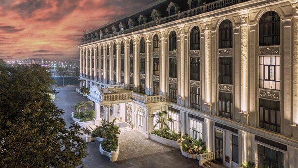A grand hotel with a symmetrical facade, large windows, and a well-maintained garden area. - Adamo Hotel Hung Yen (Yen My)