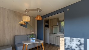 Eine moderne Küche mit Holzausstattung, fest eingebautem Herd und einem Fenster mit Jalousien.