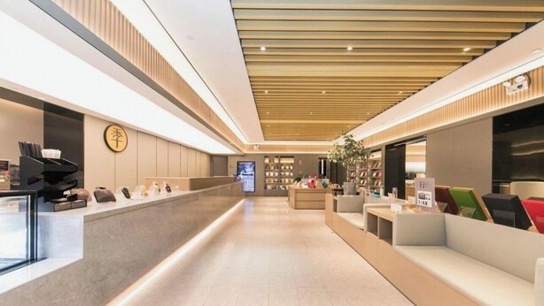 Un moderno hall de hotel con mostrador de recepción, zona de estar y exhibición de diversos objetos.