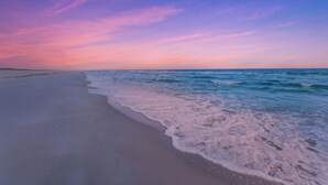 A beach with gentle waves and a clear sky.