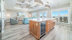 Una cocina amplia con una isla central, armarios de madera e iluminación colgante.