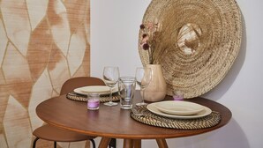 A dining table set with plates, glasses, and a woven basket. - Charming Studio Centre de Paris-montorgueil (Paris)