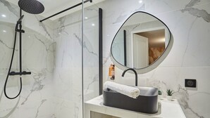 A modern bathroom with a shower, a sink with a mirror, and a towel rack. - Charming Studio Centre de Paris-montorgueil (Paris)