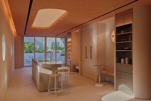A modern kitchen with a central island, bar stools, and built-in shelving.