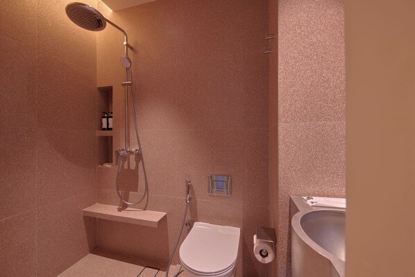 Un baño moderno con ducha, inodoro y lavamanos.