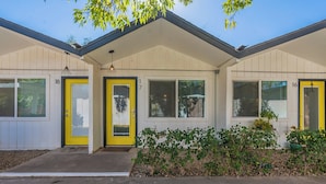 A two-story house with numbered doors and windows, a front porch, and a small garden area.