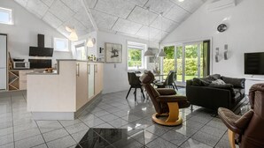 A spacious living area with a kitchen, dining space, and a large window providing a view of the outdoors.
