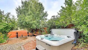 A hot tub in a garden with steps leading up to it, surrounded by trees and a wooden bench. - Relax at Fountain: Hot Tub Fun (Fountain)