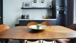 Uma cozinha moderna com mesa de jantar, cadeiras e forno embutido.