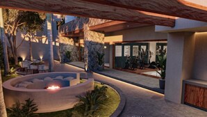 Uma área de estar moderna ao ar livre, com disposição circular de assentos, lareira e piscina.