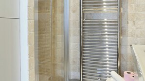 A bathroom with a glass shower enclosure, a stainless steel towel rack, a toilet, and a trash can. - Lovely Studio With AC - Center of Paris (Paris)
