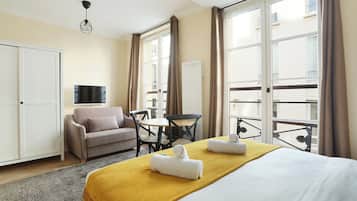 Laptop workspace, iron/ironing board, bed sheets