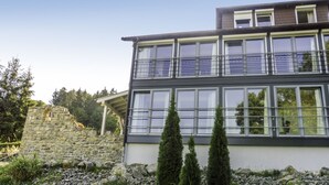 Un bâtiment moderne doté d’un mur en pierre et d’un balcon.