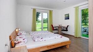 A bedroom with a bed, a desk, a chair, and a view of the outdoors. - Apartment 'Im Allgäu - Biber 1' with Private Terrace, Shared Garden and Wi-Fi (Leutkirch im Allgäu)
