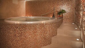 A hot tub with mosaic tile walls, a potted plant, and a staircase leading to a higher level. - Hotel Villa Fitz (Rokycany)