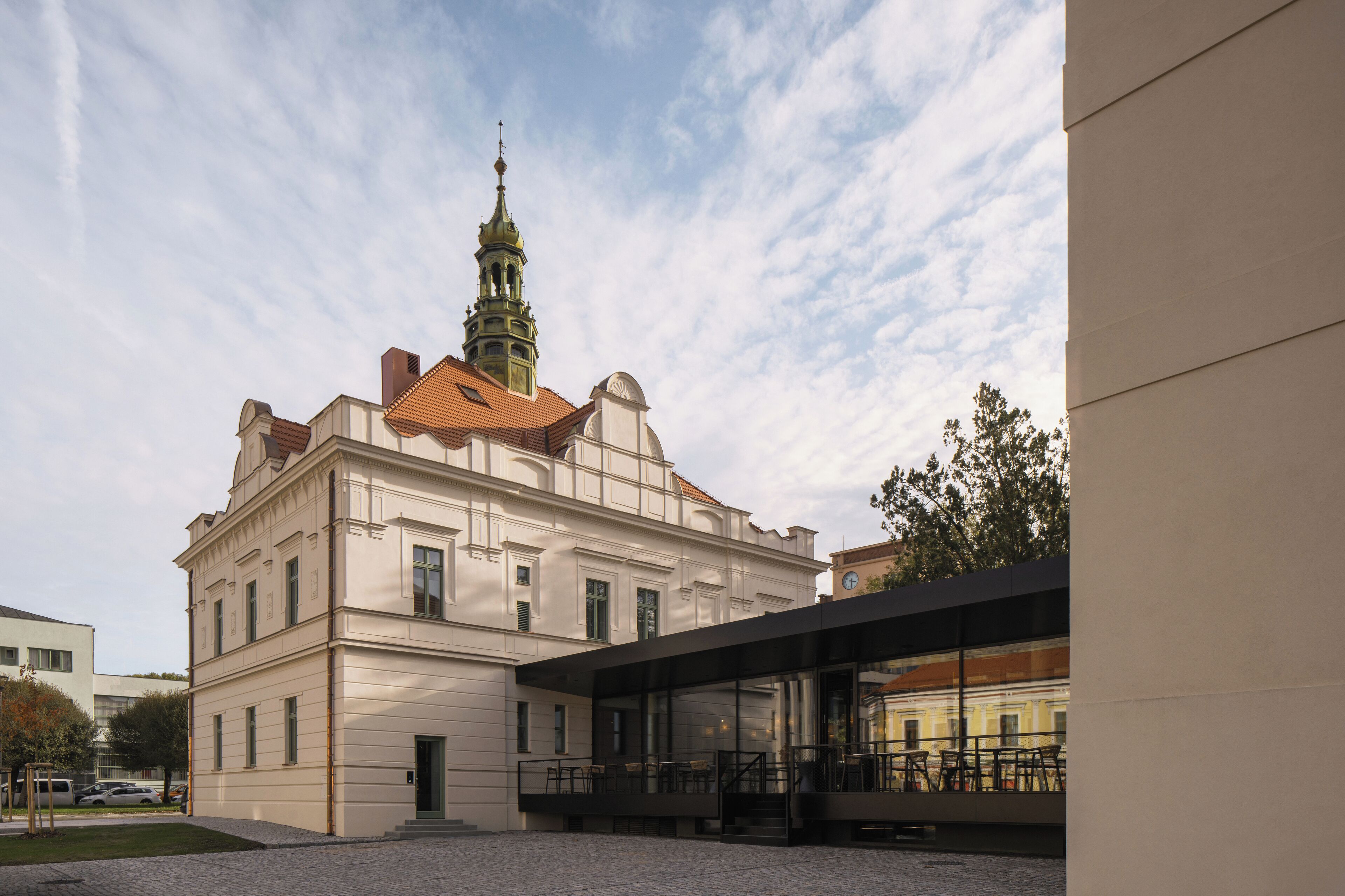 Ein historisches Gebäude mit einem markanten Turm und einem modernen Anbau.