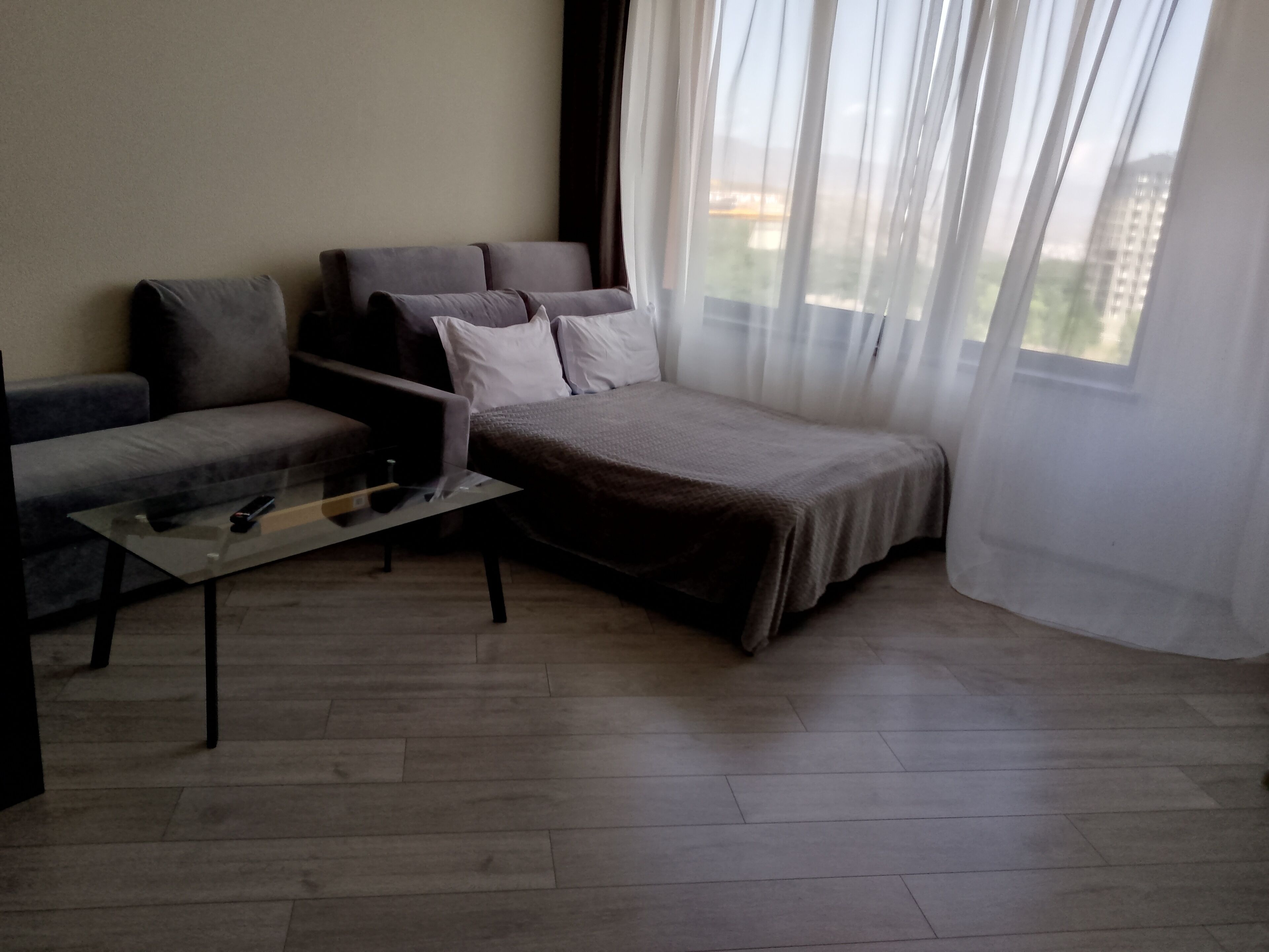 Ein modernes Wohnzimmer mit Sofa, Couchtisch und Bett.